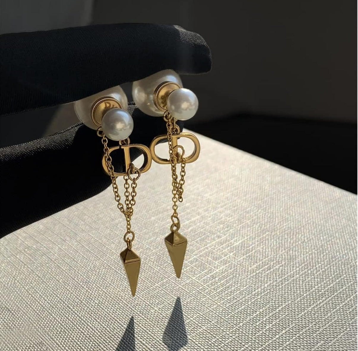 CD logo earrings with chain connect to pearl